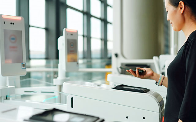 lady using auto check in at airport 640